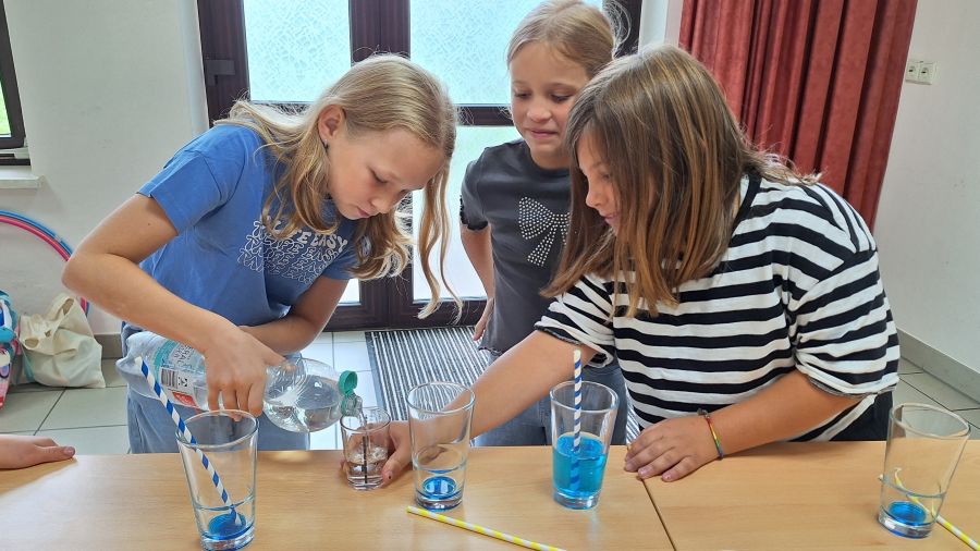 Drei Kinder beim Mixen von alkoholfreien Cocktails. | Foto: Janina Wilharm / Caritas