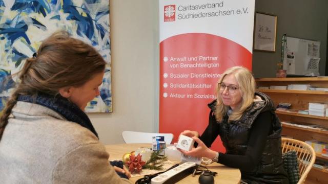 Caritas-Mitarbeiterin Michaela Krebs (r.) schaut sich mit einer Klientin eine Auswahl von kleinen Energiesparhilfsmitteln an. | Foto: Caritas