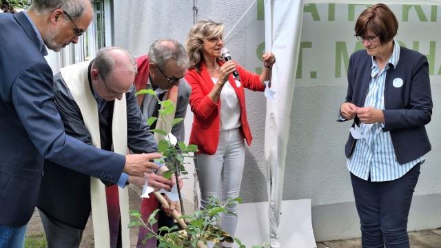 Christina Daniel-Krauß lädt alle ein, eine Friedenstaube an den neu gepflanzten Apfelbaum zu hängen. | Foto: Johannes Broermann / cps