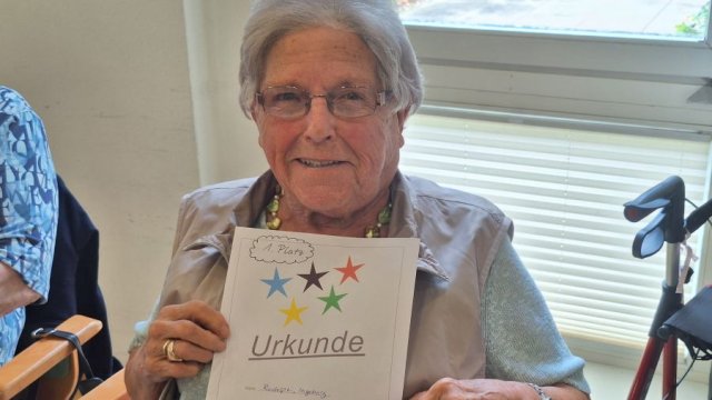 Das Bild zeigt Ingeborg Rudolphi während sie ihre Siegerurkunde hochhält.