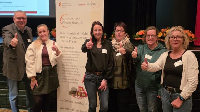 Das Foto zeigt eine Gruppe von Menschen, die alle eine Hand als Faust nach vorne strecken, dabei den Daumen in die Höhe recken.